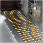 Capsules travelling along the high-speed packing line conveyor